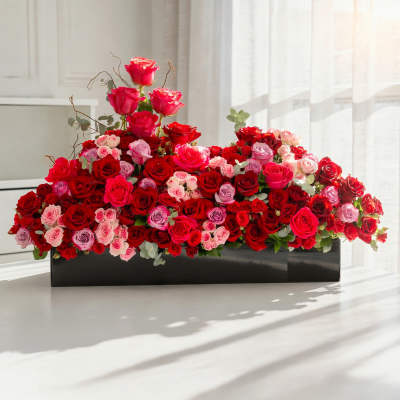 Large arrangement of red and pink roses in a black rectangular box