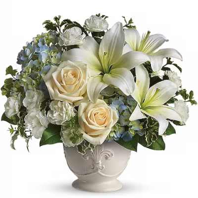 White lilies and cream roses in a decorative vase