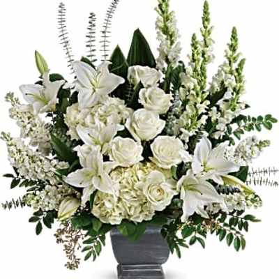 White lilies and roses arranged in a gray urn vase