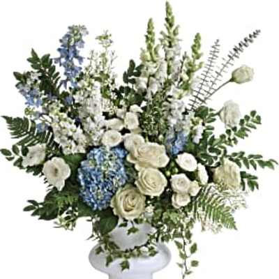 White and blue floral arrangement in a white pedestal vase
