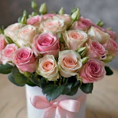 Pink and cream roses in a white hat box with a pink ribbon