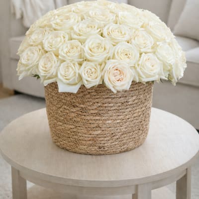 Large bouquet of white roses in a woven basket