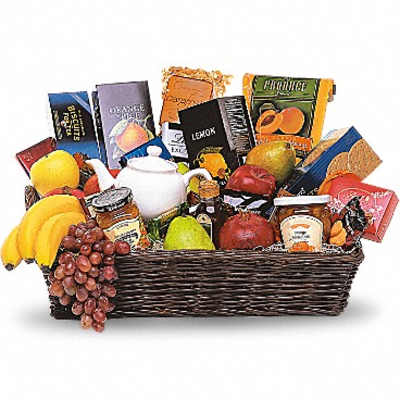 Gift basket with fruit, snacks, and a white teapot