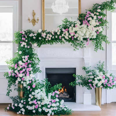 Large floral garland with pink and white roses draped around a fireplace and mirror