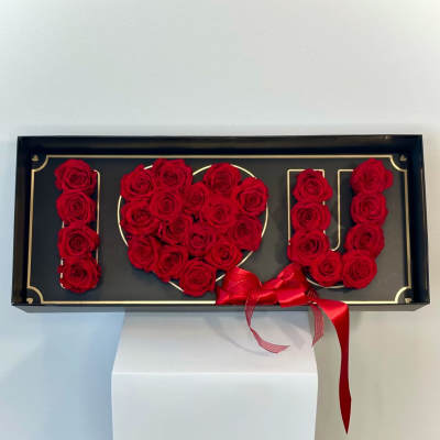 Red roses arranged in a black box to spell "I LOVE U" with a red ribbon