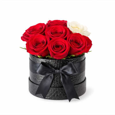 Red and white roses arranged in a black round box with a ribbon