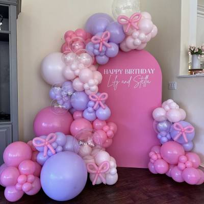 Pink and lavender balloon birthday display with a large sign reading Happy Birthday Lily and Stella