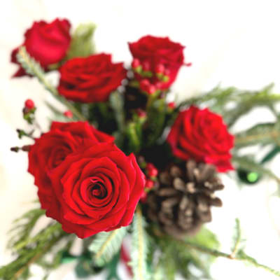 Bouquet of red roses with pinecones and greenery
