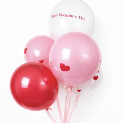 Cluster of pink, red, and white heart balloons with a Valentine’s Day message
