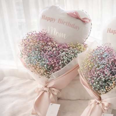 Two pastel baby’s breath bouquets with pink ribbons and birthday balloons