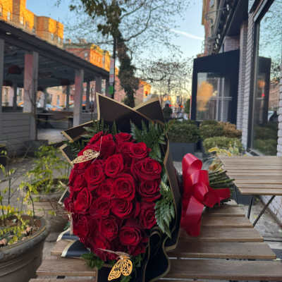 Bouquet of red roses wrapped in black paper with a red ribbon