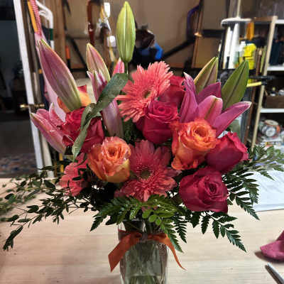 Pink and orange mixed bouquet in a clear glass vase