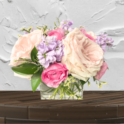 Pink and cream roses arranged in a clear glass vase