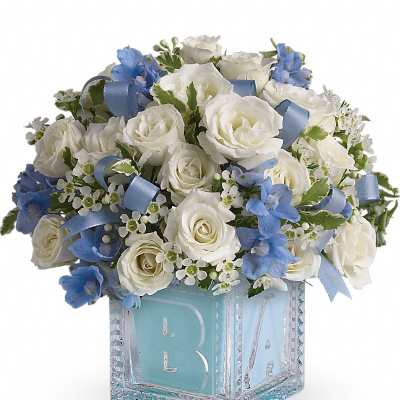 Compact white and blue flower arrangement in a blue baby block glass cube vase