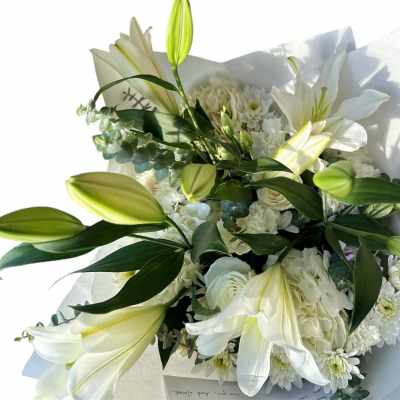 White lily bouquet with white daisies and wrapped paper