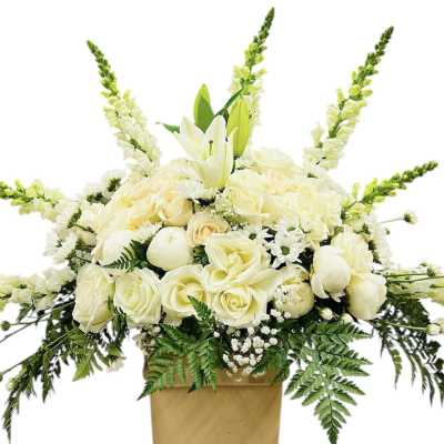 Large arrangement of white and cream roses, lilies, and snapdragons in a tan box container