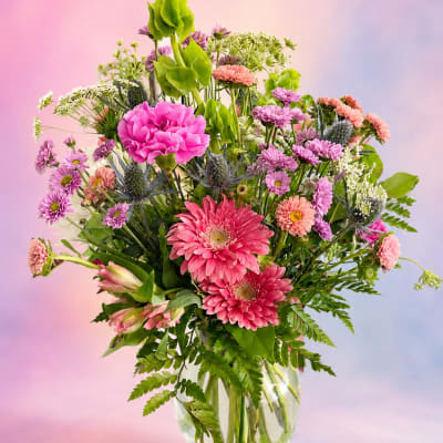 Mixed pink and purple flowers in a clear glass vase