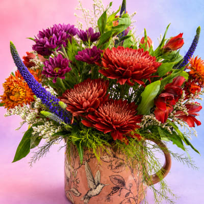 Colorful mixed bouquet in a decorative mug-shaped vase
