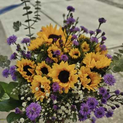Bouquet of yellow sunflowers and purple filler flowers