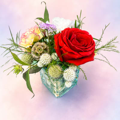 Mixed bouquet with a red rose in a glass vase