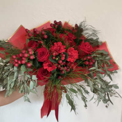 Bouquet of red roses and carnations with berries and greenery