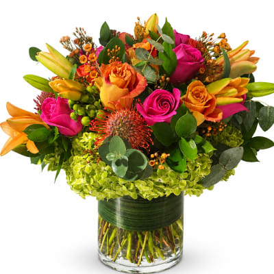 Bright mixed bouquet of roses and lilies in a glass vase