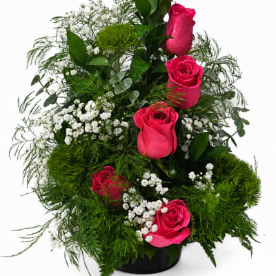 Tall arrangement of hot pink roses with white baby's breath in a black vase