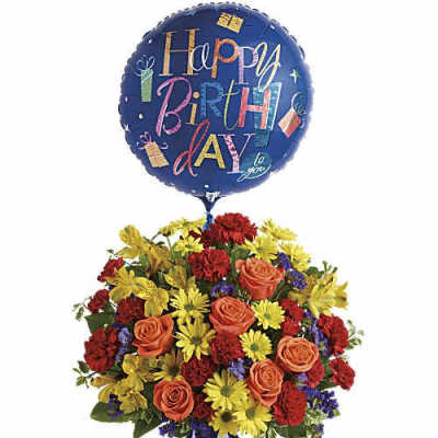 Birthday balloon above a colorful mixed flower arrangement in a blue vase