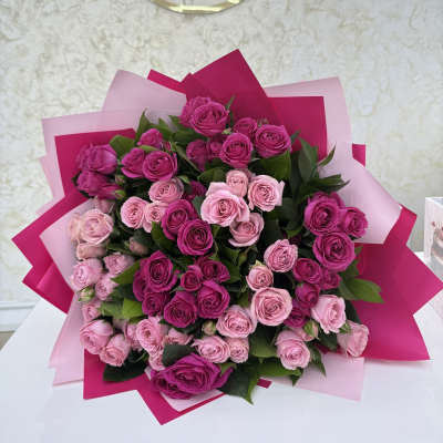 Bouquet of pink and magenta roses wrapped in pink paper