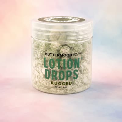 Jar of lotion drops with a pastel background