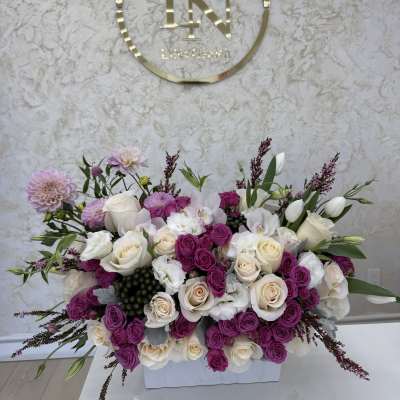 Large pink and white floral arrangement in a white container