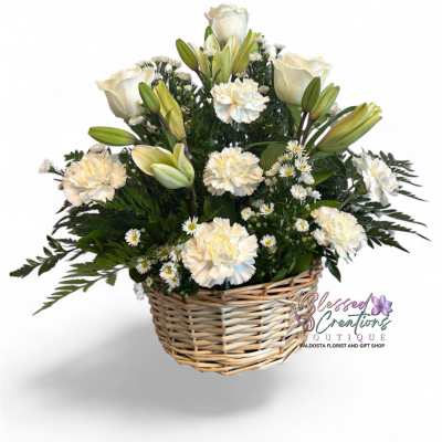 White roses and lilies arranged in a wicker basket
