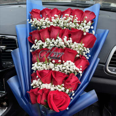 Bouquet of red roses with white baby's breath and a birthday pick