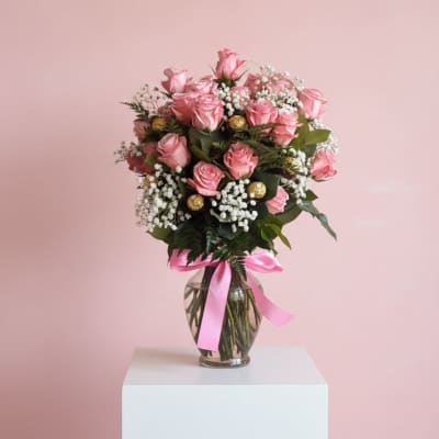 Pink rose bouquet in a glass vase with a pink ribbon