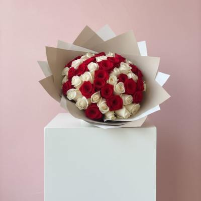 Bouquet of red and white roses wrapped in beige paper