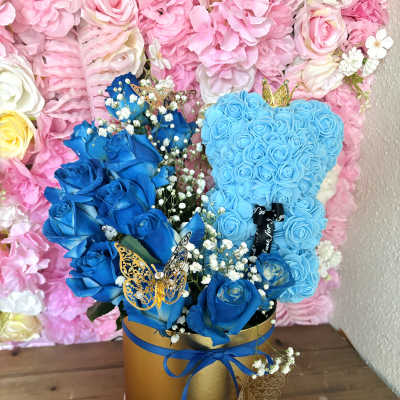 Blue rose arrangement in a gold hatbox with butterfly accents