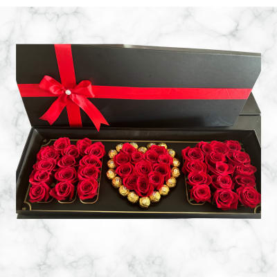 Black gift box with red roses and chocolates arranged in heart shapes