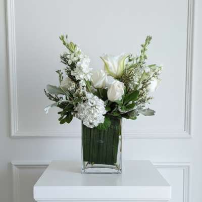 White floral arrangement in a clear rectangular vase