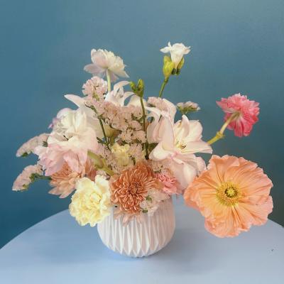 Pastel mixed flower arrangement in a white vase