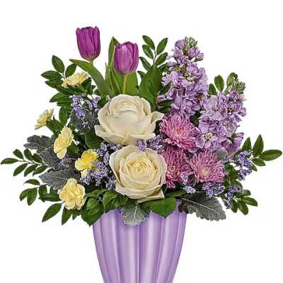 Purple and cream floral arrangement in a lavender vase