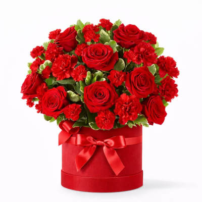 Red roses and carnations in a red hatbox with a ribbon