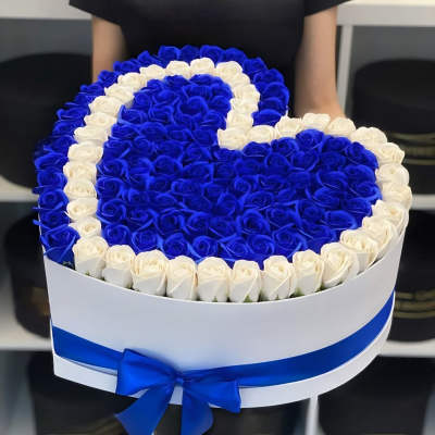 Heart-shaped box of blue and white roses with a blue ribbon