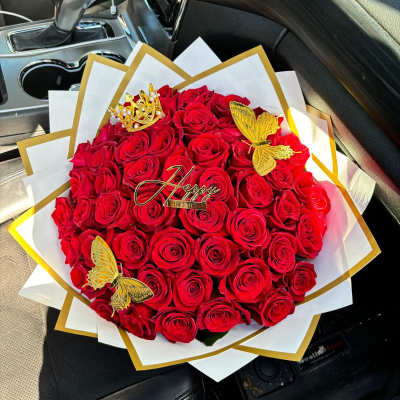 Bouquet of red roses with gold butterfly accents and a birthday topper
