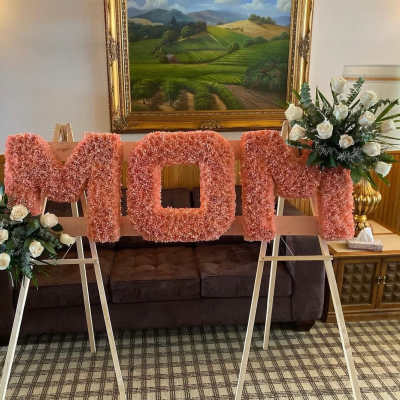 Pink floral letters on easels with white rose arrangements on both sides