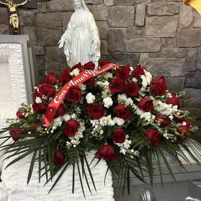 Large red rose funeral spray with white flowers and a red ribbon