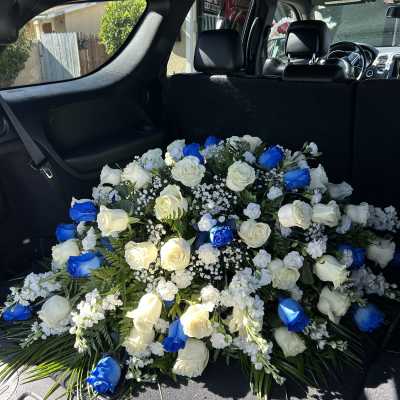 Large bouquet of white and blue roses arranged in a car cargo area