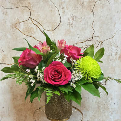Pink roses and alstroemeria in a textured vase with bright green chrysanthemum