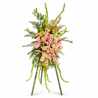 Standing floral spray with pink roses and green foliage on an easel