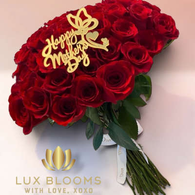 Bouquet of red roses with a gold "Happy Mother's Day" topper
