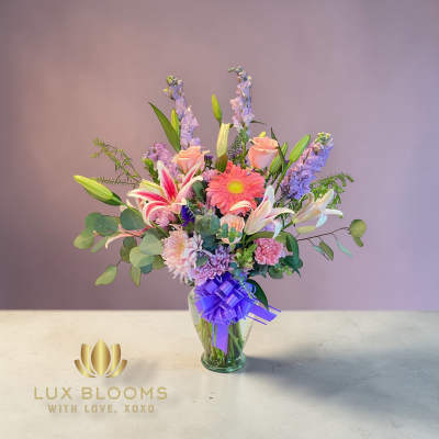 Mixed bouquet in a glass vase with lilies, gerbera daisies, and roses